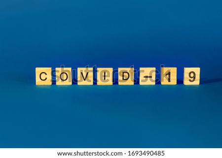 The Concept Of Coronavirus. Prevent or stop the spread of COVID-19 worldwide. Wooden letters on a blue background