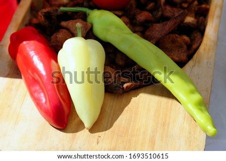 Raw organic red yellow and green peppers on natural background at market stall. Food concept with copy space.