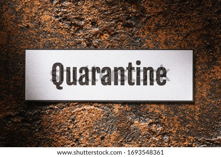 Tag with text on a rusty background. Quarantine concept