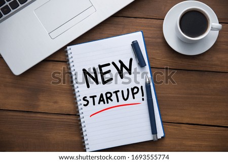 new startup on notepad  with computer on table
