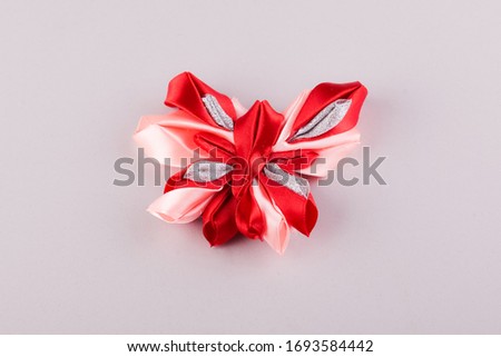 beautiful white and red handmade hair clip in the shape of a butterfly made using the kanzashi technique