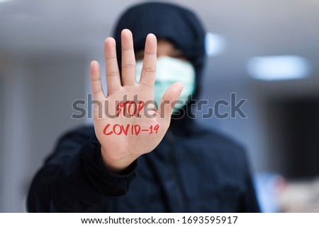 A man with surgical mask and STOP Covid-19 on The hand, Covid-19 crisis 