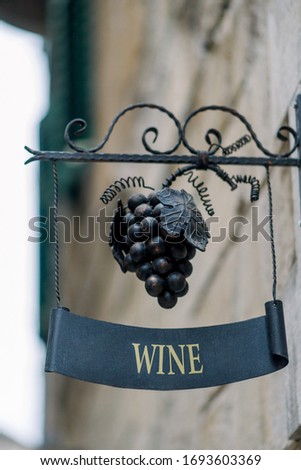 Sign of a wine store with the words "wine." Shod bunch of grapes street decor, advertising.