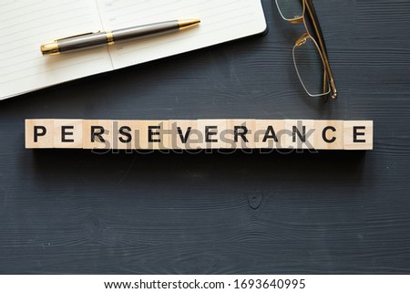 Modern business buzzword - perseverance. Top view on wooden table with blocks. Top view. Close up.