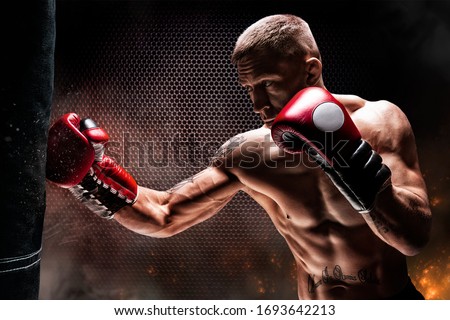 Kickboxer punches the bag. Training a professional athlete. The concept of mma, wrestling, muay thai. Mixed media Royalty-Free Stock Photo #1693642213