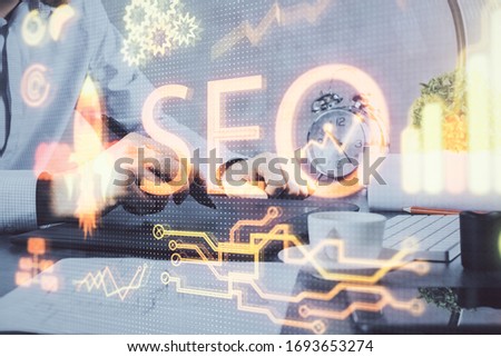 Multi exposure of man's hands holding and using a digital device and seo drawing. search optimization concept.