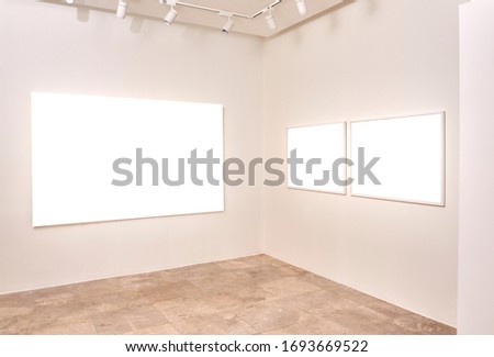 two white empty frame and one blank canvas at exhibition 