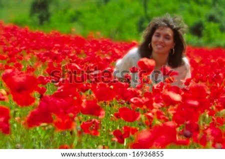 Young woman in a poppies field. Image taken with a Flou Filter, to make a beautiful defocused effect.