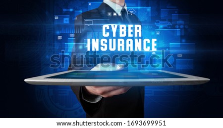 Young business person working on tablet and shows the digital sign: CYBER INSURANCE