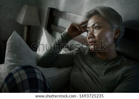 mature lady crisis - attractive middle aged woman with grey hair sad and depressed in bed feeling scared and lonely thinking worried about covid-19 virus pandemic during home lockdown Royalty-Free Stock Photo #1693725235