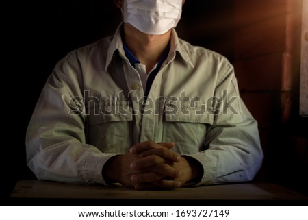 Man wearing mask for protect pm2.5 and Covid-19. He praying in the morning for a new day freedom to corona virus. Asian men hand praying for thank GOD. Copy space.