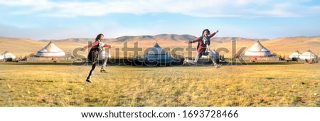 A man cloned into two people running around in the country side with the background of tents or and blue sky in Mongolia Royalty-Free Stock Photo #1693728466