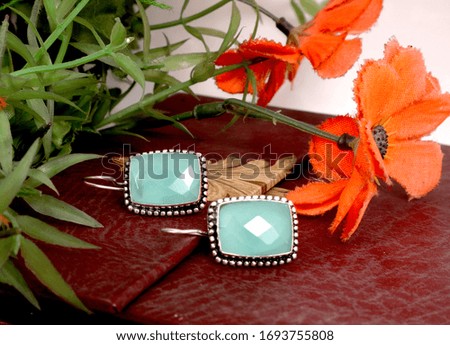 Earrings are designed in such a way that people are attracted to them, their photo was taken on a colorful background.