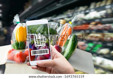 Online order grocery shopping on touch screen concept. Woman hand holding smart phone with checks the bar code or e-wallet on label for ingredient and payment. Business and technology for lifestyle. Royalty-Free Stock Photo #1693765159