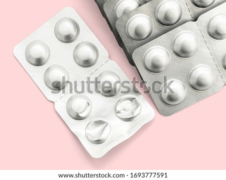 A large number of capsules in a silver package on a pink background, isolate, close-up. A large number of medications for the treatment of various diseases. Tablet for all diseases and viruses.