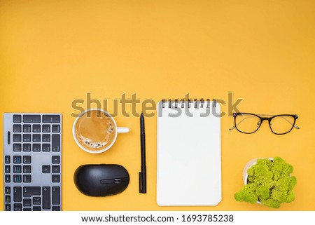 Modern workplace, top view. Flat lay composition with tablet, keyboard, computer mouse, coffee and other office related objects on yellow background