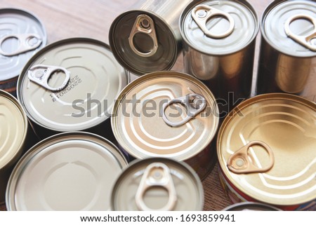 Various canned food in metal cans on wooden background , top view / canned goods non perishable food storage goods in kitchen home or for donations Royalty-Free Stock Photo #1693859941