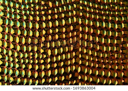 Adorable shiny texture of artificial skin. Neon colors. HIghtlight on bulging parts. Textured bright background. Gold with green background. Textured background.