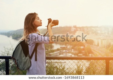 Female Photographer taking pictures outdoors during travel with panoramic view
