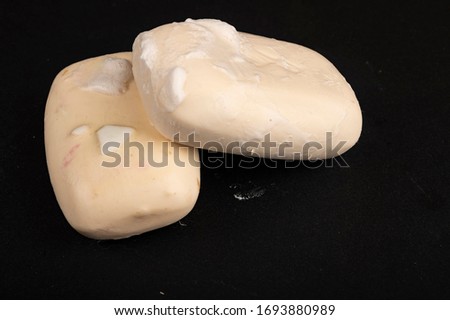 Two pieces of toilet soap on a black background. Frequent hand washing with soap is a prevention of COVID-19 infection. Close up.
