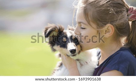 young girl with her puppy in her arms