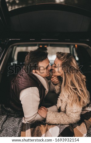 Loving couple in a car in the winter forest, NOISE EFFECT ON PHOTOS