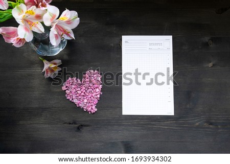 Flat lay calendar with pink heart and planning on dark wooden background top view
