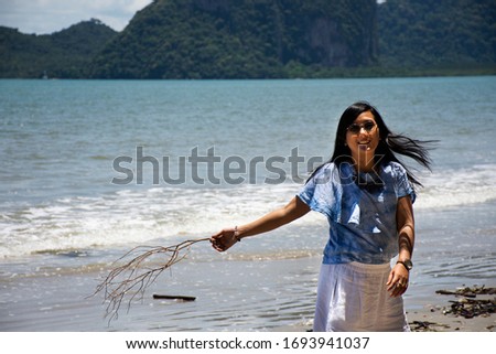 Traveler thai women relax on the beach and portrait posing for take photo with wave water of sea and island at Hat Chao Mai beach and marine national park in Sikao and Kantang at Trang, Thailand.