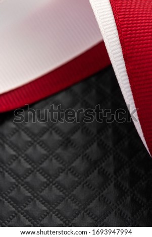 Closeup of red ribbon on black background. Mockup for macro shot of jewelry, cosmetics or product still life 