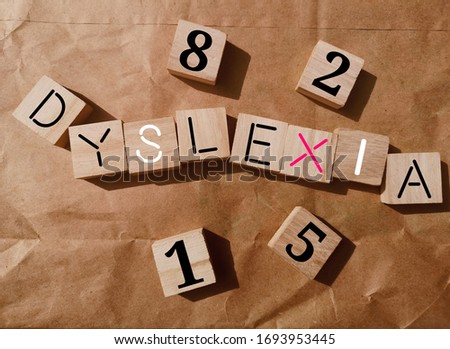 dyslexia concept - alphabet wood blocks on brown paper background with selective focus/shadow.

