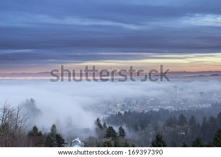 Portland Oregon Downtown Cityscape Covered in Fog and Low Clouds at Sunset with Mount Hood