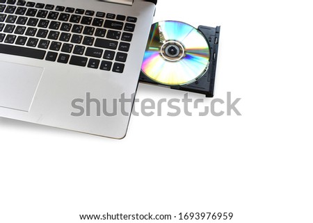 Place the CD or DVD ROM in the laptop computer Isolated on white background. Clipping path