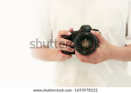 Professional photographer standing and holding camera in studio preparing to shoot model taking photo. Studio camera cameraman photographer photography concept