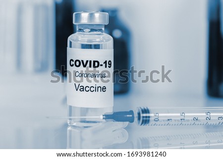 Coronavirus vaccine - The medical concept. Ampoule and syringe. Copyspace. blue toning. Royalty-Free Stock Photo #1693981240