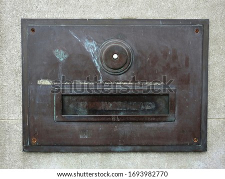 Old metal letterbox on stone wall. 