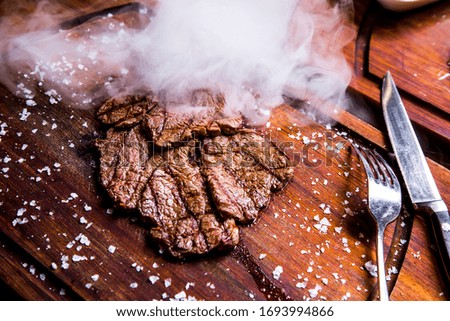 steaming steak on wooden board  side view