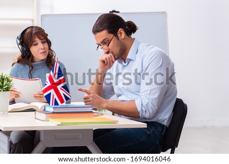 Young female student and male english teacher in the classroom