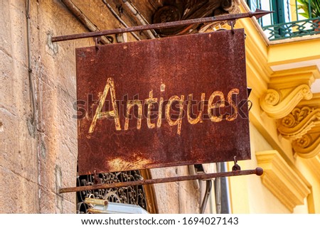 Old rusty sign of an antiques shop
