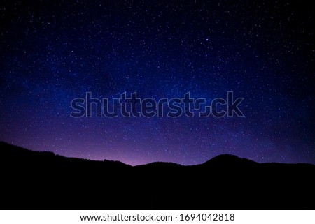 Germany, Magical moving galaxy milky way over black forest tree silhouette in dark night