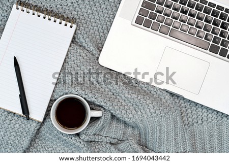 Flat-lay of Cosy working writing place with warm sweater coffee, note paper and phone. work from home. Writing. 