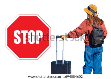 Travel ban. Concept - closing borders in connection with quarantine. Girl was blocked from entering the country. Canceled the visa. Woman with a travel suitcase next to a stop sign. Traveler