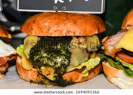 Fresh melting burger ready to eat during fast food festival. Outdoor catering event, brunch or outside dinner party with fast food. Melting cheese and golden bun. Appetizing closeup homemade burger