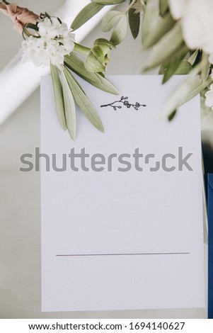 Wedding details. On the table is an invitation and a bouquet of flowers