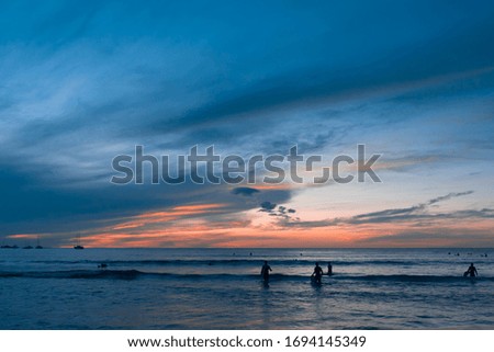 Sunset in Tamarindo with people enjoying the Pacific Sea. Pura Vida scenes in Costa Rica. Central America.