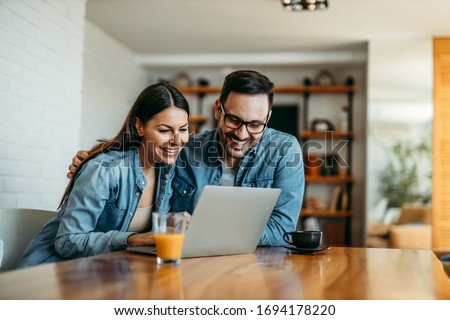 Loving couple hugging and looking at laptop, portrait.