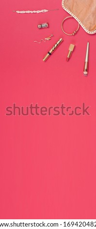 Vertical picture. Content of a woman's handbag in the shape of sunlight. Golden accessories for women's beauty on saturated pink background. Geometry, Flat lay, overhead view, copy space