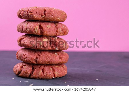 Oatmeal and beet cookies, on a on black wooden table. Food, holiday, cooking, baking background. Concept of home and healthy eating. Front views with clear space.