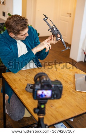 blogger man keen on engineering and modern smart technologies and devices, he show his new purchase to subscribers, sit in front of camera and talk about advantages and disadvantages