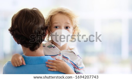 Family with kids in face mask in shopping mall or airport. Father and child wear facemask during coronavirus and flu outbreak. Virus and illness protection, hand sanitizer in public crowded place. Royalty-Free Stock Photo #1694207743
