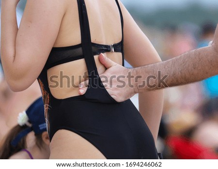 A man applies sunblock to the girl’s back. Holiday at the resort